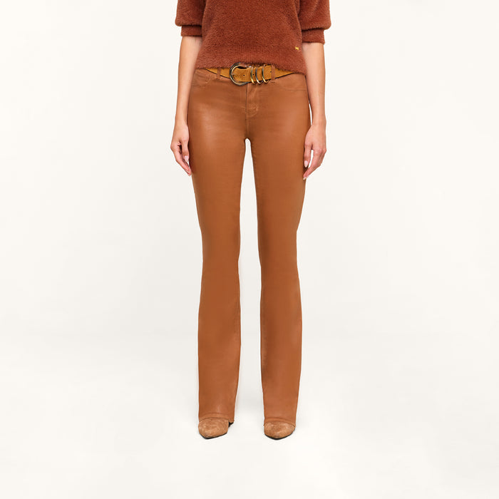 A person wearing a dark java brown sweater, the Selma Coated Bootcut Jean, and tan shoes stands against a plain white background.