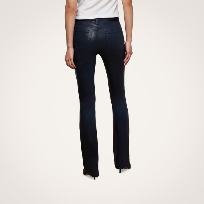 A person wearing the Selma Coated Bootcut Jean in black and a white top stands facing away, displaying the back view of the outfit against a plain white background.
