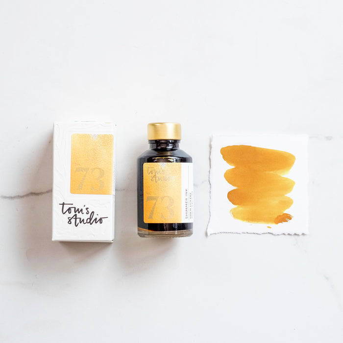 Tom's Studio Golden Lustre Shimmer Fountain Pen Ink – featuring the packaging, bottle and a swatch on paper