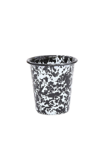 Short enamel cup with black and white splatter texture on white background