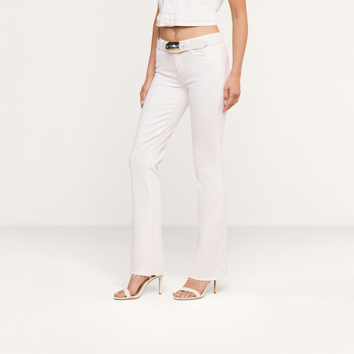 A person stands against a plain white background, showcasing only the lower half of their body while wearing the Sneeki Low-Rise Straight-Leg Jean paired with a white sleeveless crop top and nude heeled sandals.