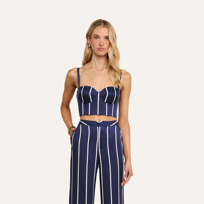 Wearing the Sonya Bustier and matching high-waisted pants with white vertical stripes, a woman with long blonde hair stands against a plain light background.