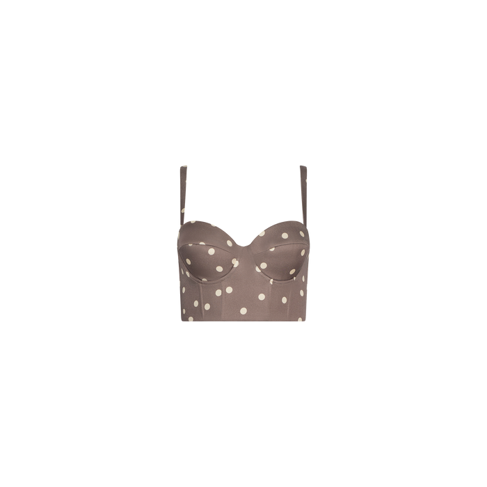The Sonya Bustier is a brown cropped top made from lightweight twill, featuring thin adjustable straps, a smocked back, and a cardamom polka dot pattern, displayed on a plain white background.