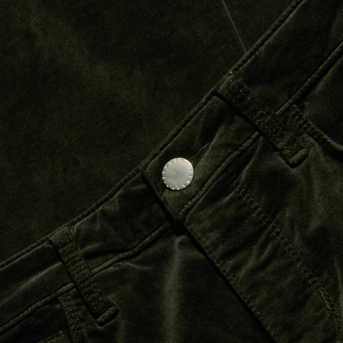 Close-up of the Stevie Velvet Jean in dark green stretch velvet, highlighting the high-rise waistband, belt loops, silver button, and a glimpse of the front pocket.