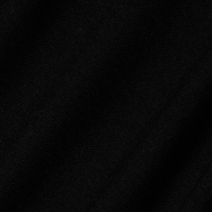 Close-up of black fabric with a subtle diagonal weave pattern visible in the texture, characteristic of the Stormy Cropped Cotton Tee crafted from organic cotton in a semi-relaxed fit.