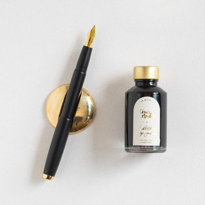 Contents of the Studio Fountain Pen Gift Set including Studio Fountain pen in Black with Medium Gold nib, Deep Black Fountain Pen Ink and Solid Brass Pen Rest.