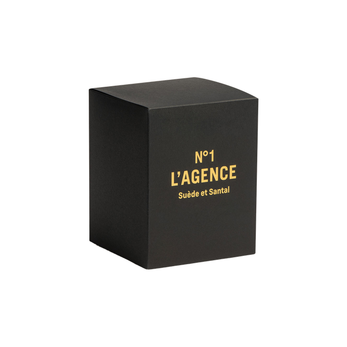 A black box featuring gold text that reads “Suède et Santal” on the front is displayed against a plain white background, highlighting its luxurious sandalwood candle made from a soy-blend wax.