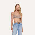 A woman wearing the Taline Crocheted Bralette paired with light blue jeans and a beige belt, standing against a plain, light background.