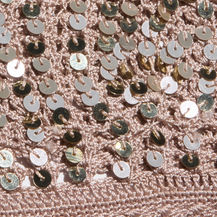 Close-up of the Taline Crocheted Bralette in pink, featuring textured crochet fabric adorned with shiny gold sequins that create a sparkly, eye-catching pattern across the surface.