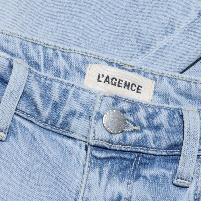 Close-up of the Tati Cropped Micro Boot Jean in light wash, stretch denim, featuring a silver button and a white LAGENCE label in bold black letters above the waistband.