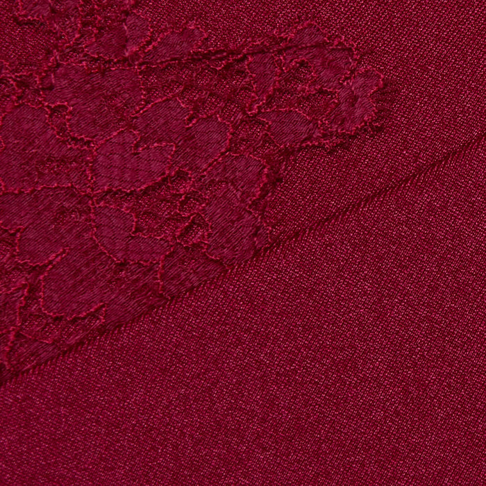 Close-up of the Terra One-Piece Swimsuit in dark red fabric, showcasing a diagonal seam. One side presents a plain knit texture, while the other is enhanced with matching lace trim, echoing the delicate detailing of this stylish swimwear.