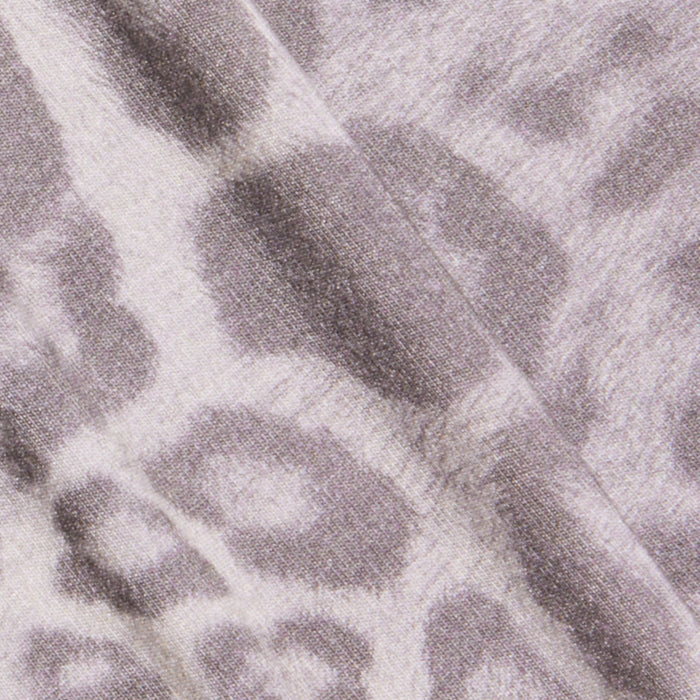 Close-up of the Tess Long Sleeve Tee featuring a soft fabric with a gray leopard print pattern that resembles leopard spots. A visible seam runs diagonally across the material.