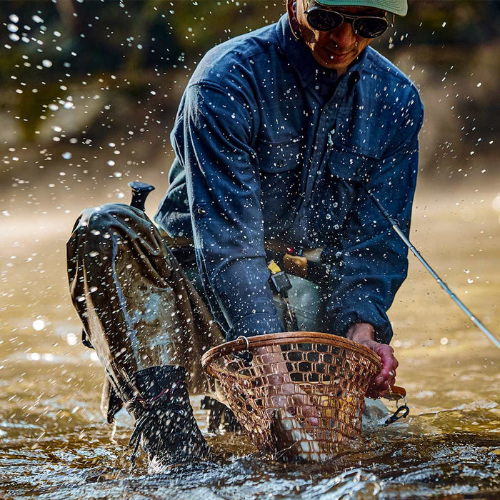 Man catches fish wearing Blue Goose flannel shirt