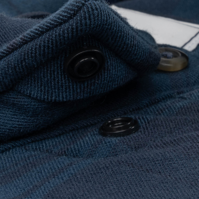 Close-up of dark blue fabric and snap buttons detail on The Blue Goose shirt, highlighting texture and design.