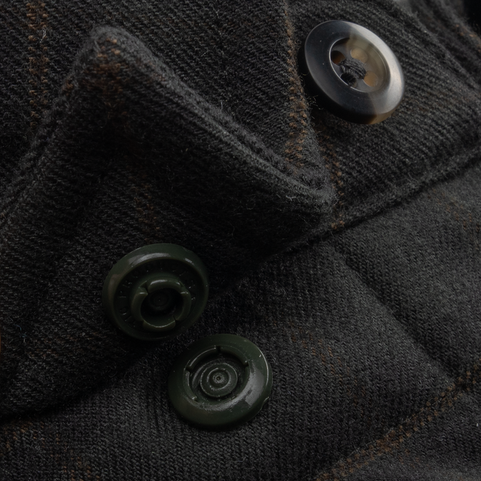 Close-up of button and snap details on the textured fabric of The Gloucester shirt in dark tones