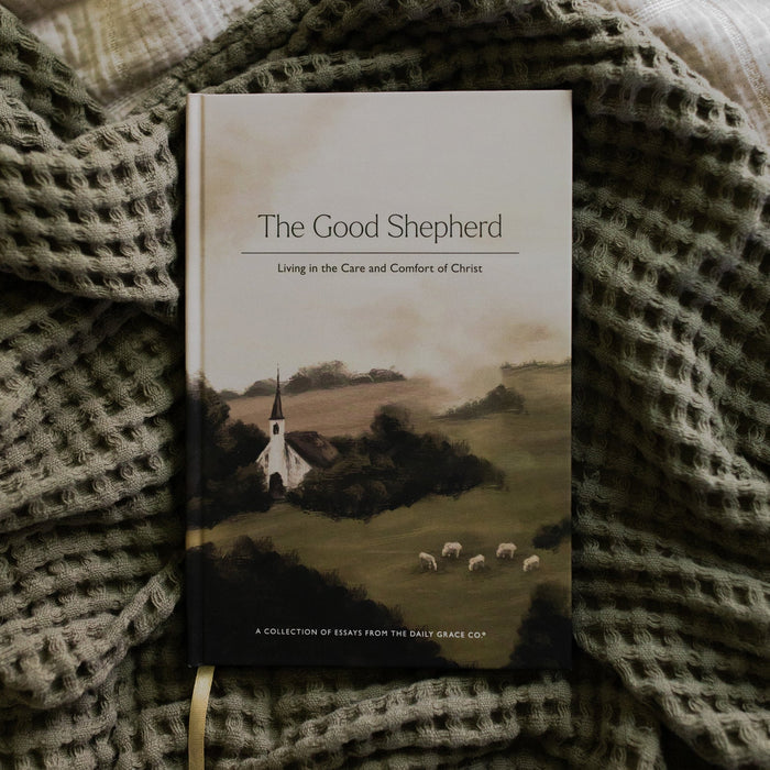 The Good Shepherd Cover laying on a green waffle styled blanket on another creme blanket