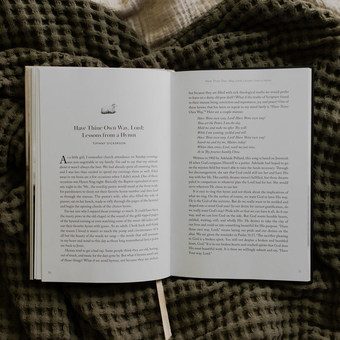 The Good Shepherd opened to the Have Thine Own Way, Lord Lessons from a Hymn page laying on a green waffle styled blanket on another creme blanket