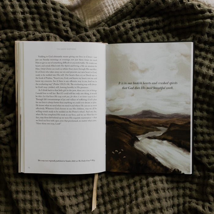 The Good Shepherd opened to page 72, a devotional and an image, laying on a green waffle styled blanket on another creme blanket