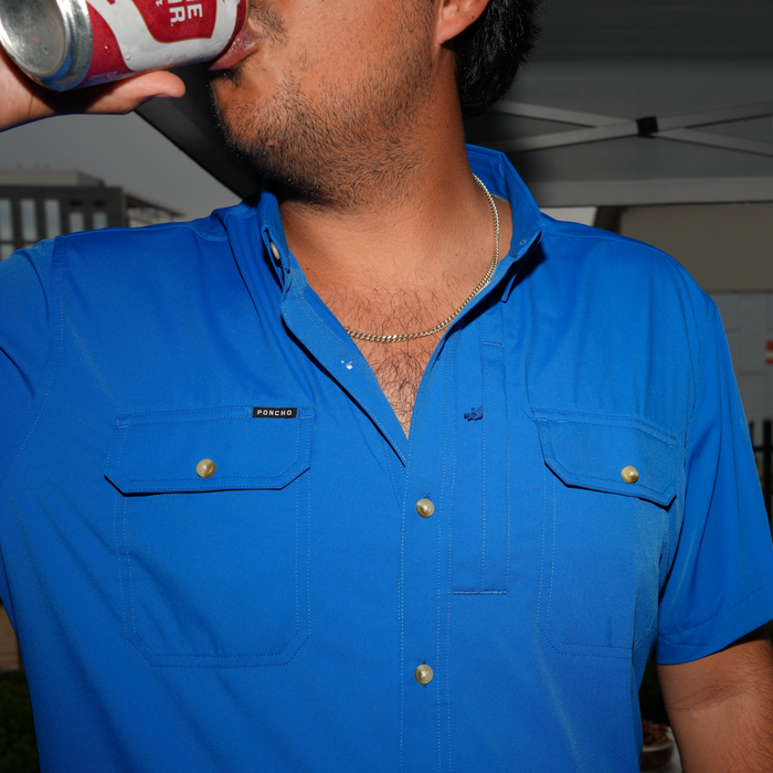 The Grandstand blue button up shirt worn while drinking from a can