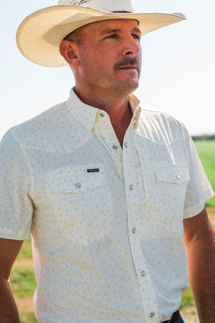 Man wearing The Medicine Bow patterned shirt and cowboy hat outdoors in sunlight