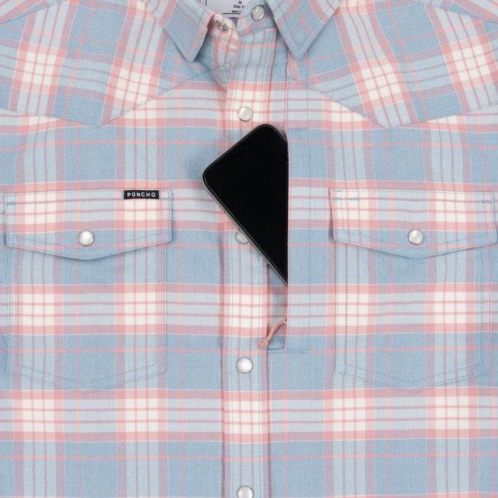 Close-up of The Pacific City shirt in pastel plaid with snap buttons and a smartphone tucked in the chest pocket