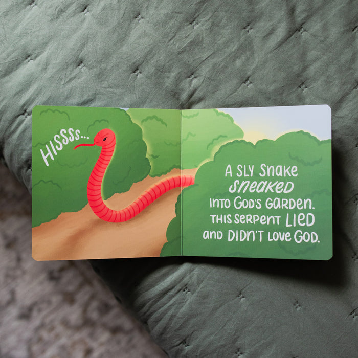 The Story of the Bible The Problem and the Promise Children's Book opened to a snake slithering page on a green blanket