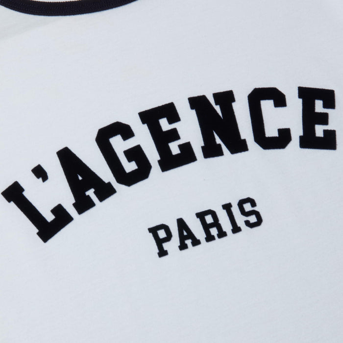 A close-up of the Tommie Crewneck Tee, crafted from white Supima cotton and featuring bold, collegiate-style black text that reads LAGENCE PARIS.