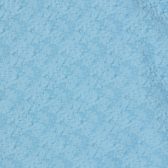 Close-up of the Tory Bandeau One-Piece Swimsuit in light blue bouclé fabric, featuring a subtle floral or geometric pattern woven throughout the material.