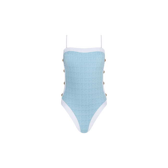 The Tory Bandeau One-Piece Swimsuit features a light blue textured bouclé fabric with white trim, thin adjustable straps, and side button details, displayed against a plain white background.