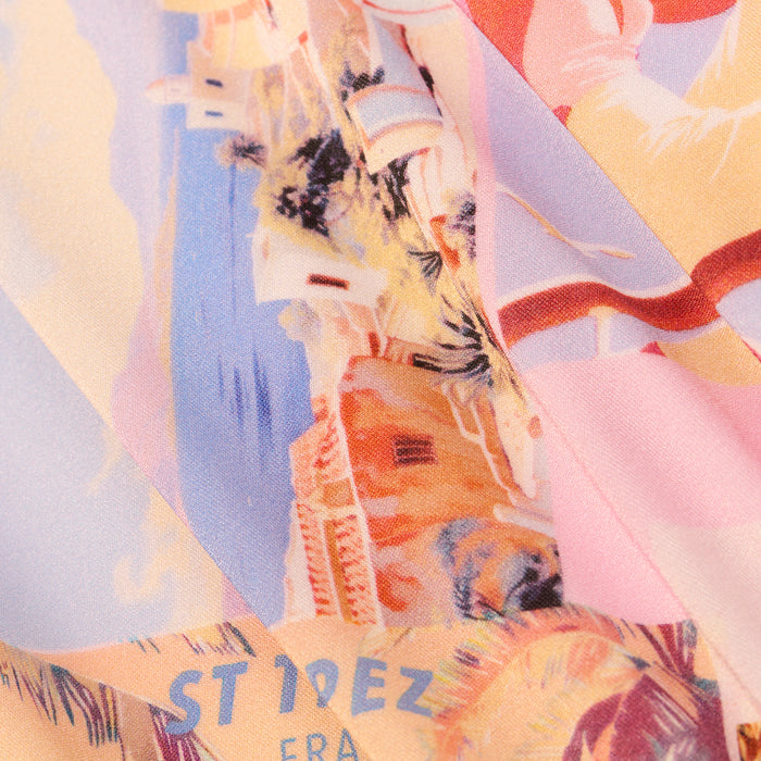 A close-up of colorful fabric from the Vanessa High-Waisted Bikini Bottom, featuring an abstract illustration with buildings, clouds, and the partial text ST IDEZ ERA in yellow and blue, reminiscent of a postcard print.