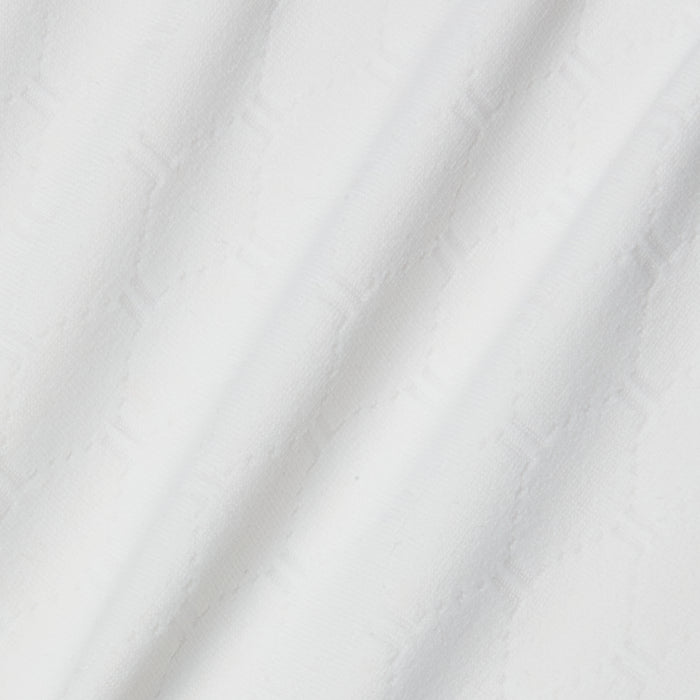 A close-up of white textured fabric with a subtle geometric hexagon pattern and soft diagonal folds, similar to the material used in the Violet String Bikini Bottom, which offers moderate coverage and UPF 50 protection.