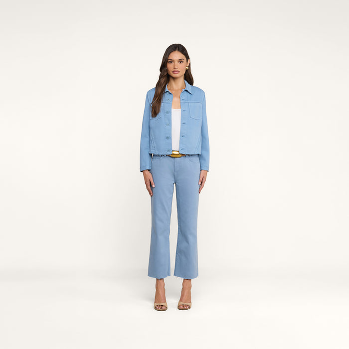 A woman stands facing forward wearing the Wanda Cropped Wide-Leg Jean paired with a matching light blue cropped denim jacket, a white top, yellow belt, and beige heeled sandals against a plain white background.