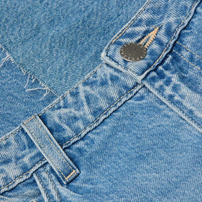 Close-up of the Wanda Cropped Wide-Leg Jean in light blue, crafted from 100 cotton denim, featuring a belt loop, metal button, visible stitching, and a pocket with frayed detailing.