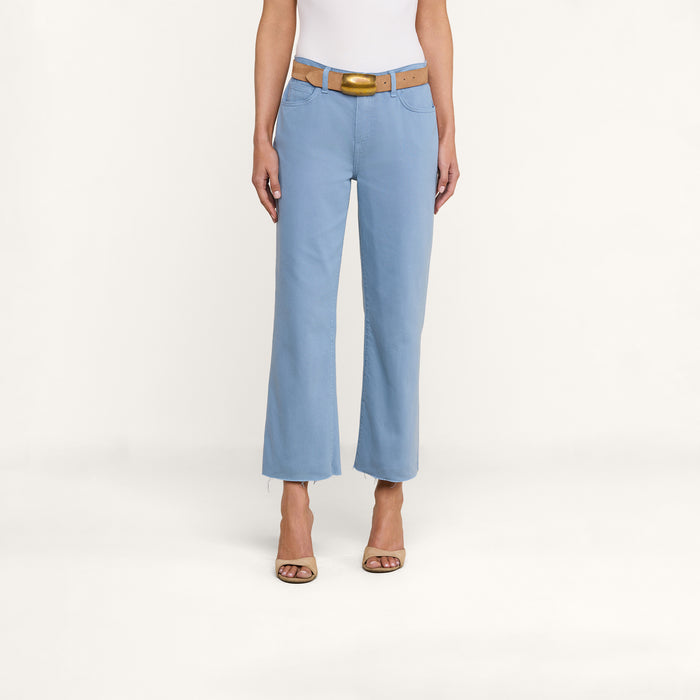 A person wearing the Wanda Cropped Wide-Leg Jean, paired with a beige belt, a white top, and beige heeled sandals stands against a plain white background.