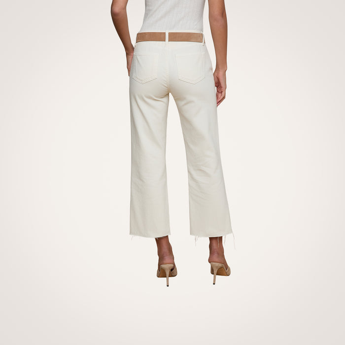 Wearing the Wanda Cropped Wide-Leg Jean in an off-white ecru wash with frayed hems, a woman stands facing away, styled with a beige belt and beige high-heeled shoes against a plain white background.