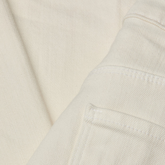Close-up of the Wanda Cropped Wide-Leg Jean in a lightweight ecru-wash denim, highlighting stitched seams, a folded edge, and part of the pocket. The image showcases the fabric’s texture and weave in detail.