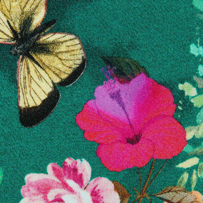 A close-up of the Yazmin Bikini Top showcases its colorful butterfly floral print fabric, featuring a yellow and black butterfly near bright pink and red flowers on a green background.